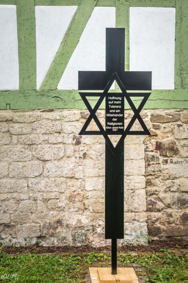 Stele aus Metall: Schwarzes Kreuz mit eingeschriebenem Davidstern