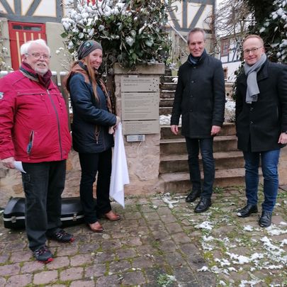 4 Personen enthüllen eine Haustafel