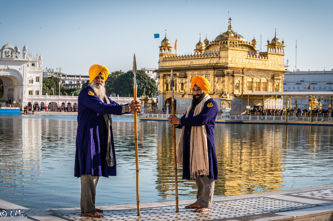 2 Männer am Wasser vor einem goldenen Tempel